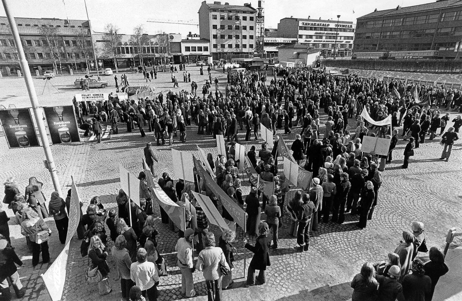 Mustavalkoinen valokuva vuodelta 1973 Jyväskylän keskustasta, jossa suuri joukko ihmisiä kokoontunut torille Työläisnuorisopäivien mielenosoitukseen. Etualalla näkyy marssijoita kantamassa kylttejä ja banderolleja, taustalla lisää väkeä sekä kerrostaloja ja kaupparakennuksia.